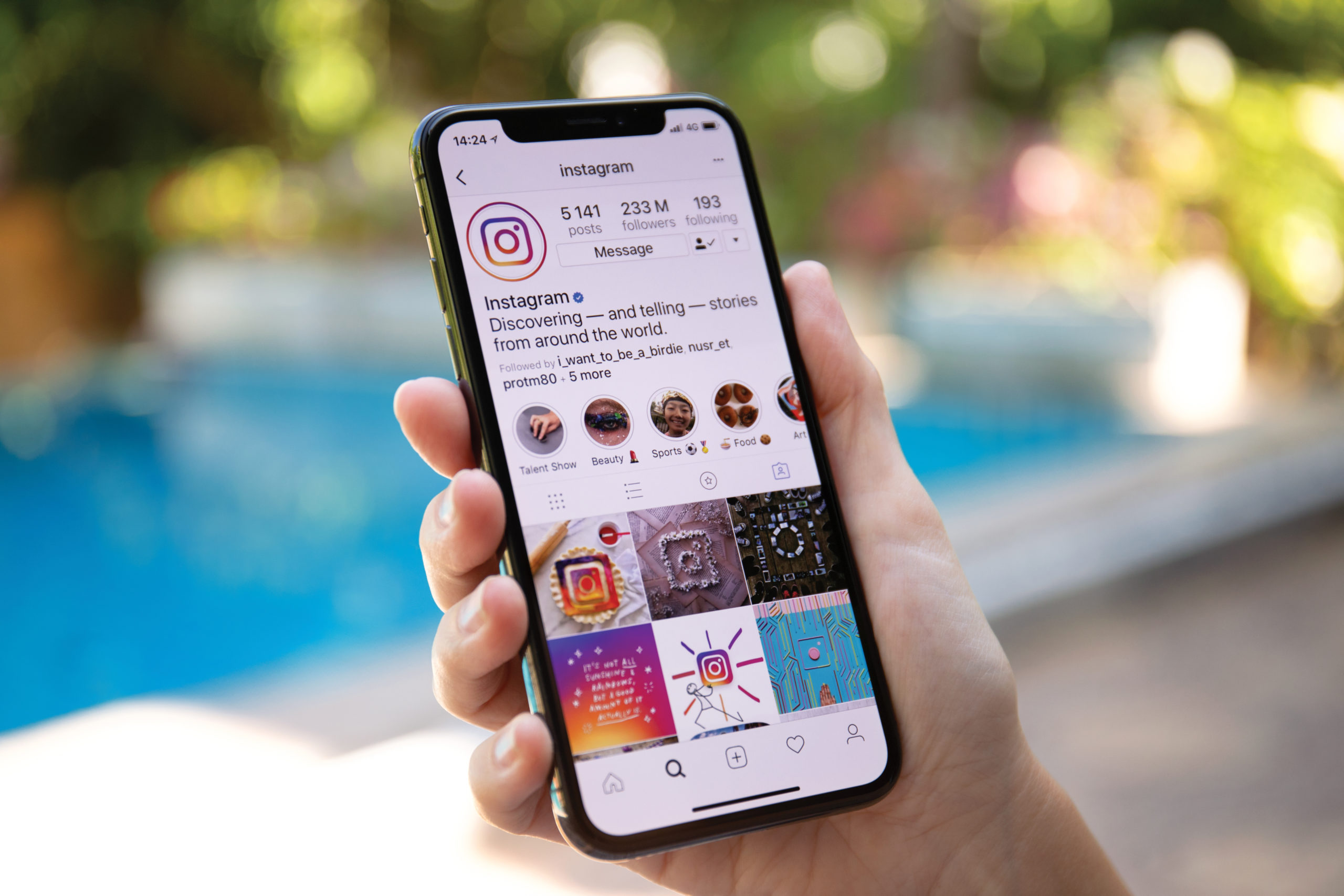 Woman hand holding iPhone X with social networking service Insta
