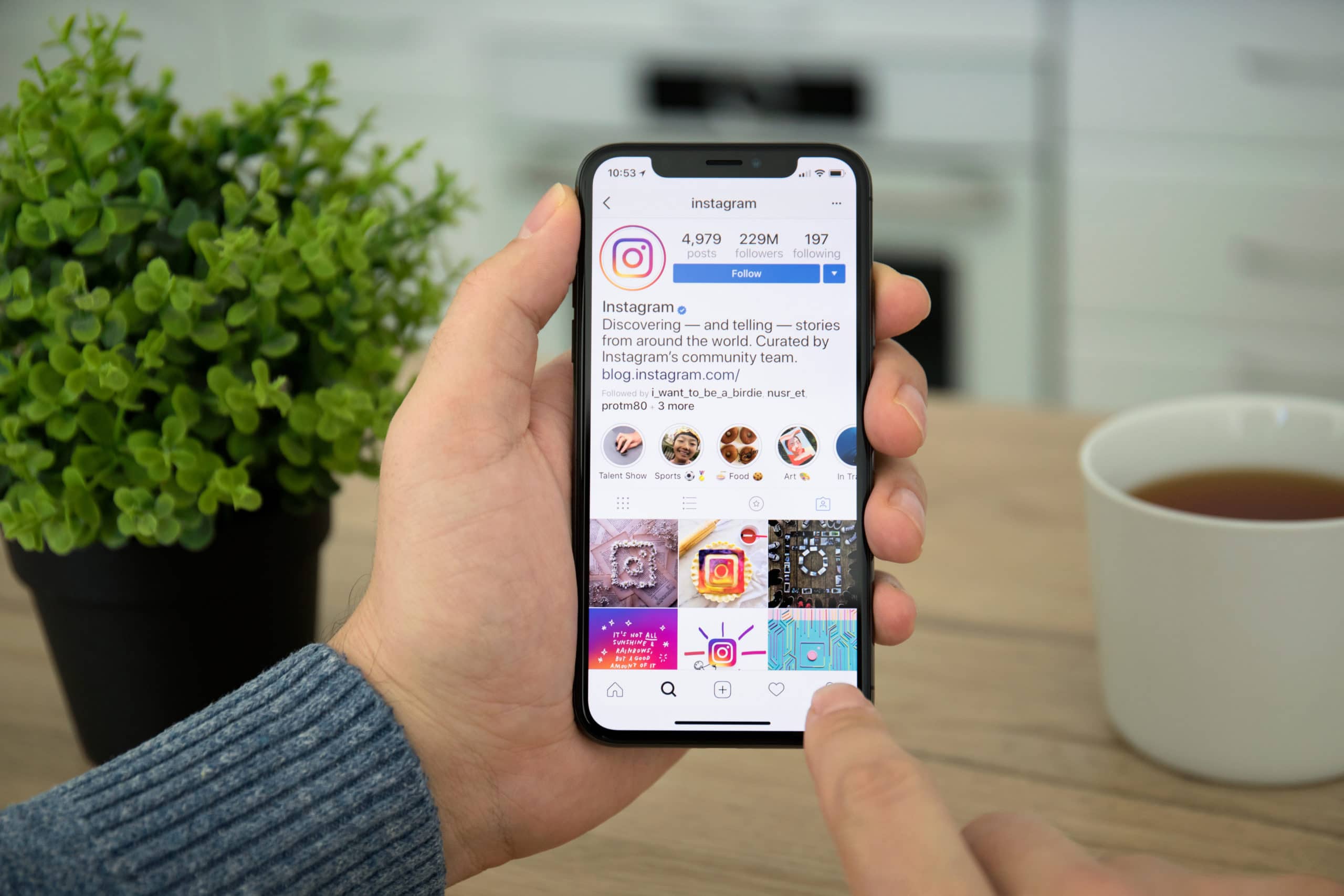 Man hand holding iPhone X with social networking service Instagram on the screen. iPhone 10 was created and developed by the Apple inc