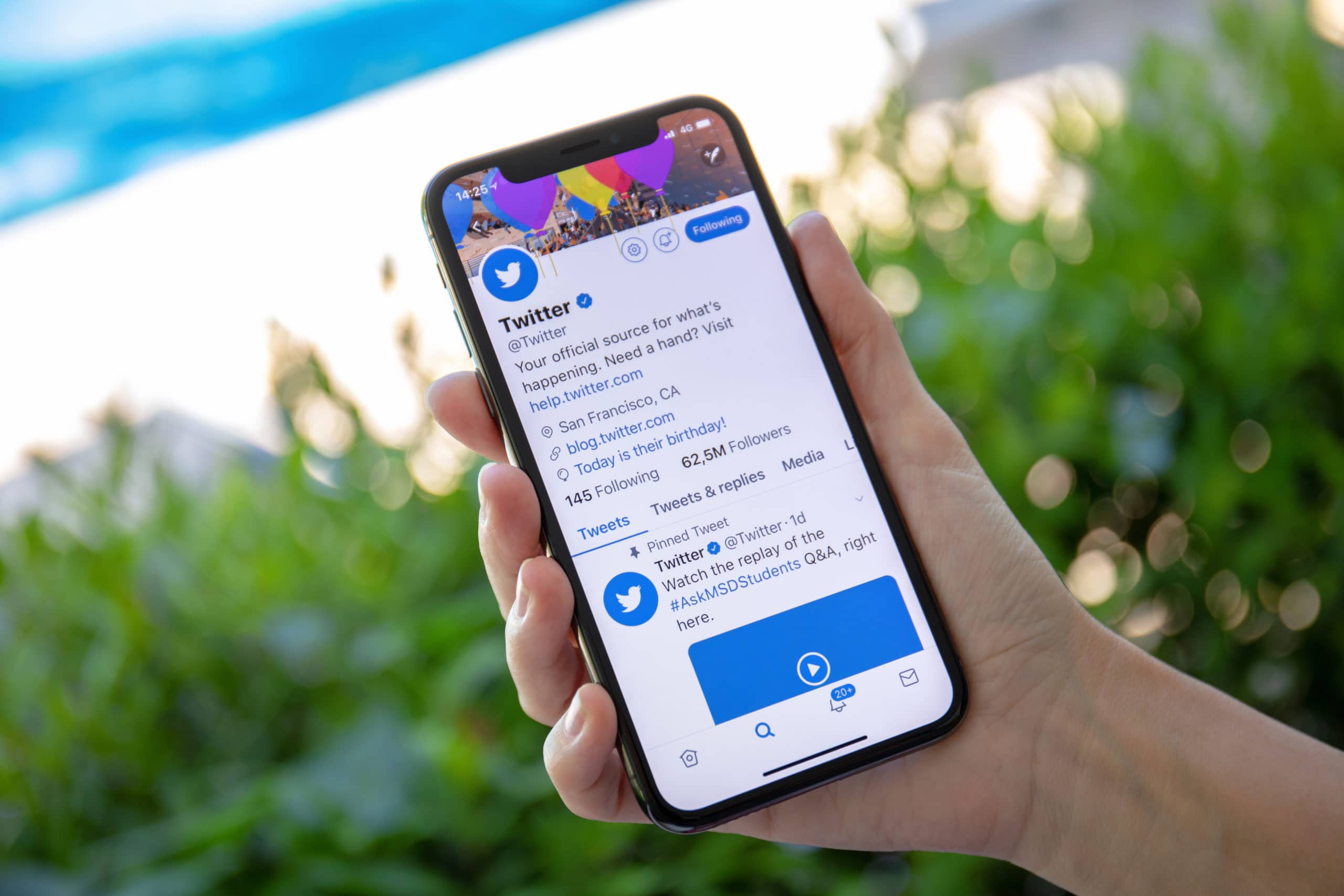 oman hand holding iPhone X with social networking service Twitter on the screen. iPhone 10 was created and developed by the Apple inc.