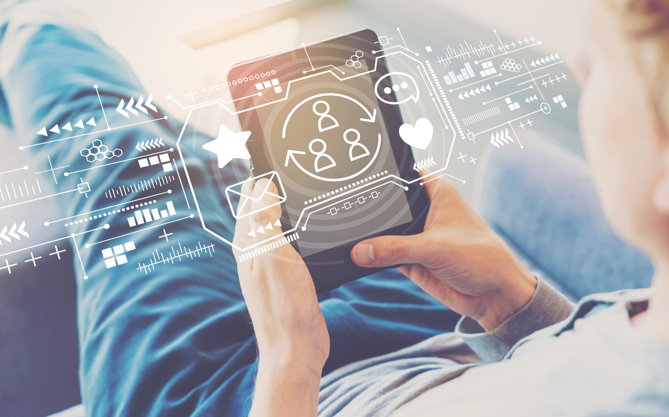 Social media theme with man using a tablet in a chair