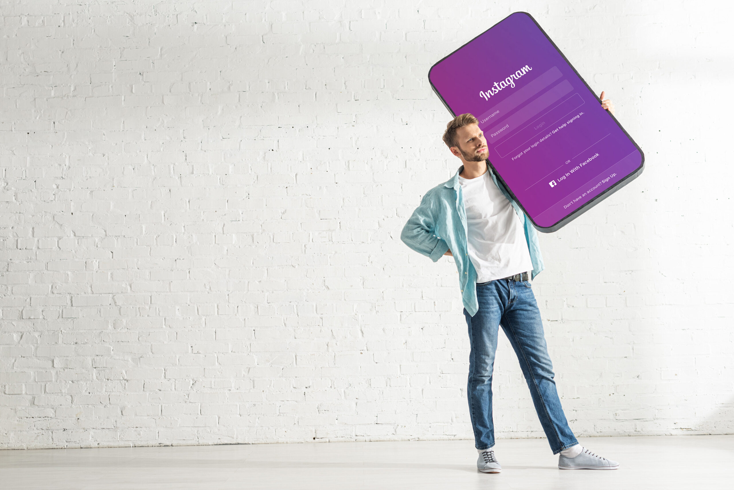 Handsome man holding model of smartphone with instagram app